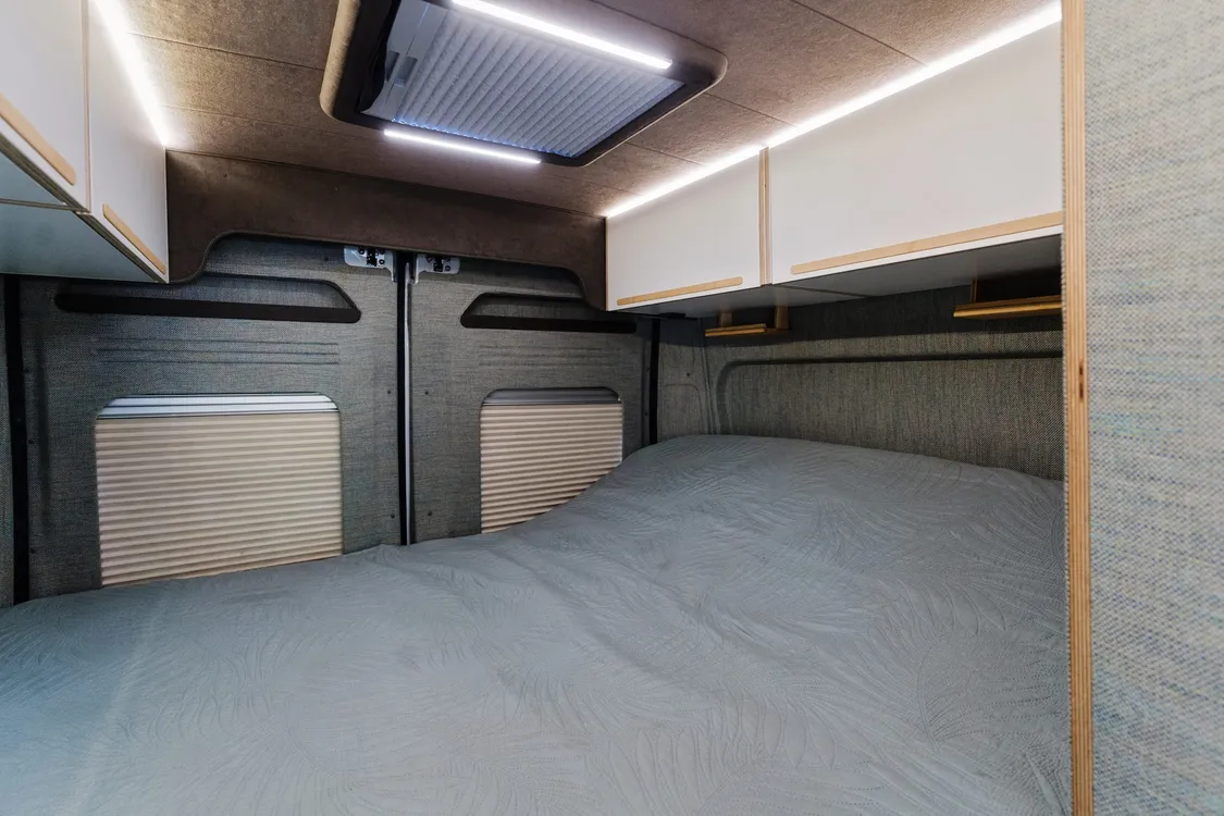 Made-up bed at the rear of the van