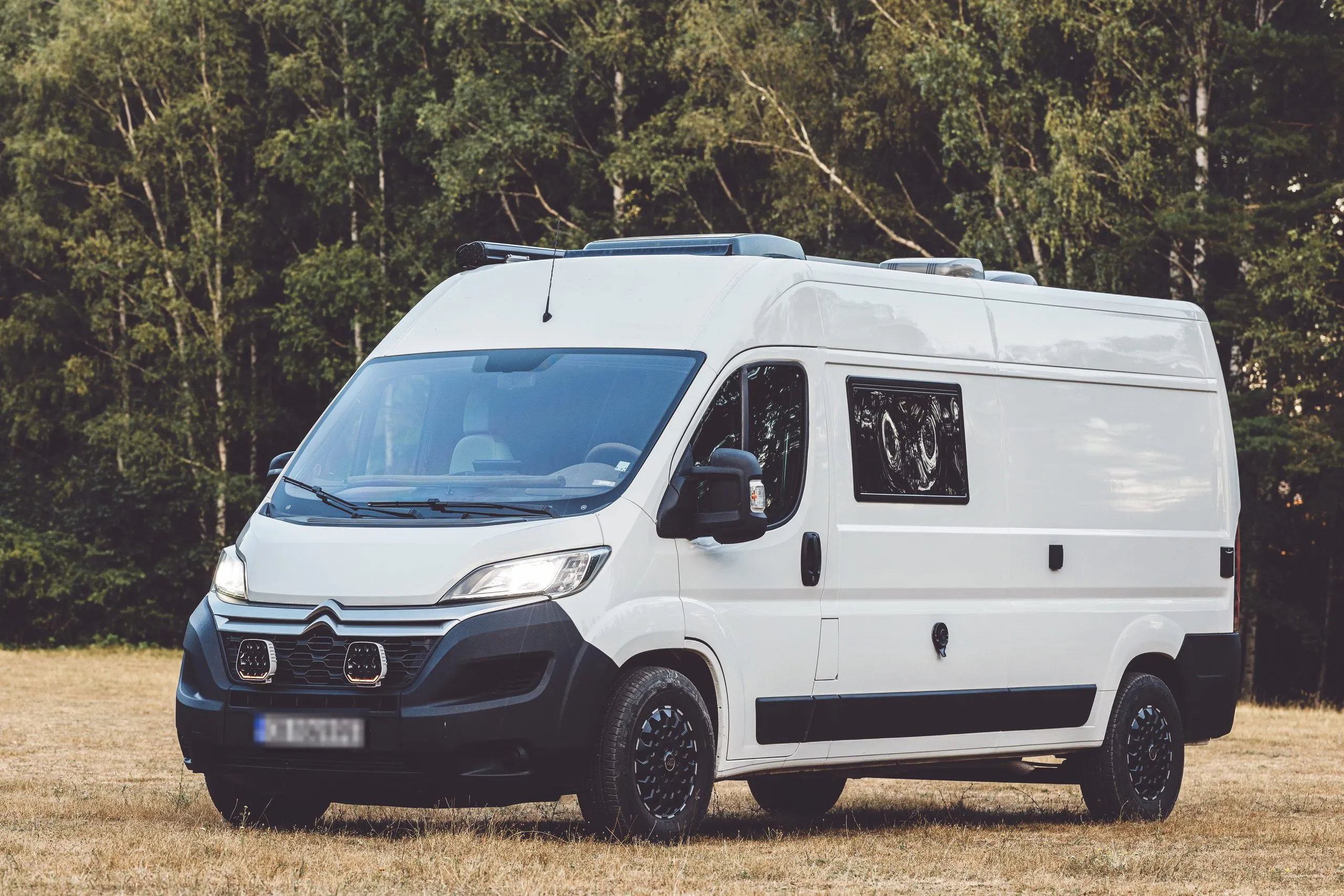 The Forest Stream van, front three-quarter view in the forest